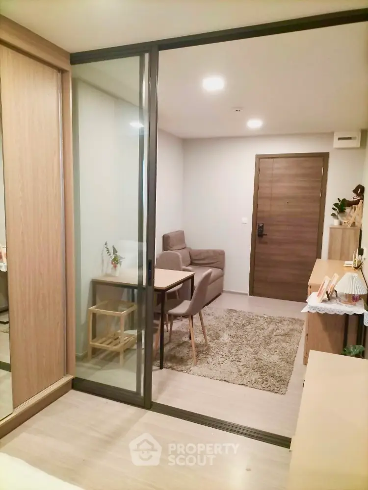 Modern apartment interior with sliding glass doors and cozy seating area.