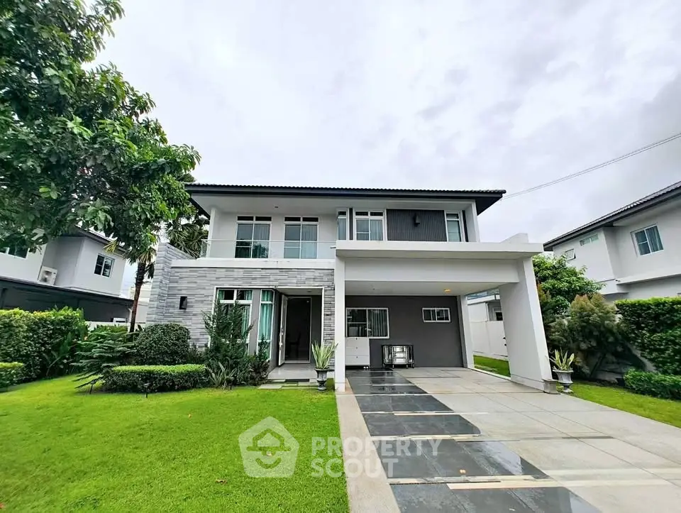 Modern two-story house with lush green lawn and spacious driveway