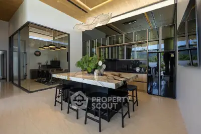 Luxurious modern kitchen with marble island and sleek black cabinetry in open-concept design.