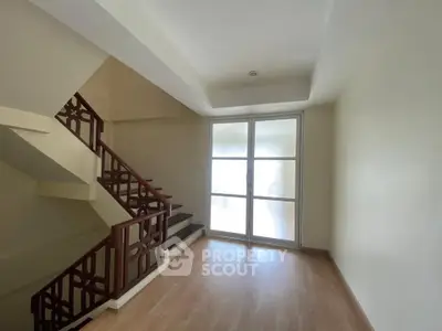 Bright stairway with wooden flooring and glass door in modern home