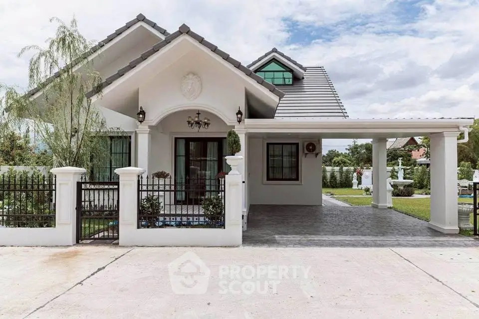 Charming white house with spacious driveway and lush garden, perfect for family living.