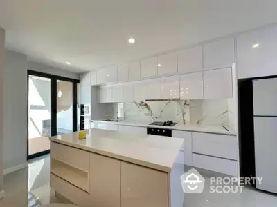 Modern kitchen with sleek white cabinetry and marble backsplash