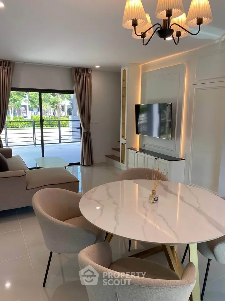 Modern living room with elegant dining area and large windows for natural light.