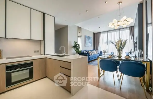 Modern open-plan kitchen and living room with stylish decor and natural light.