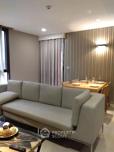 Modern living room with stylish sofa and dining area in open layout apartment.