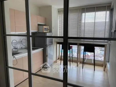 Modern kitchen with open layout and city view, featuring sleek cabinetry and breakfast bar.