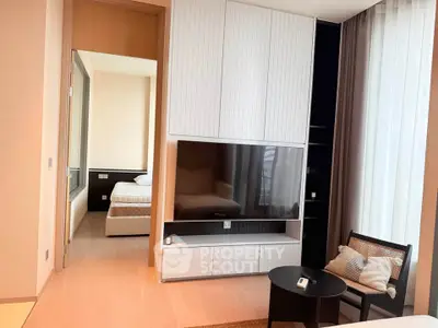 Modern living room with stylish furniture and view into a cozy bedroom