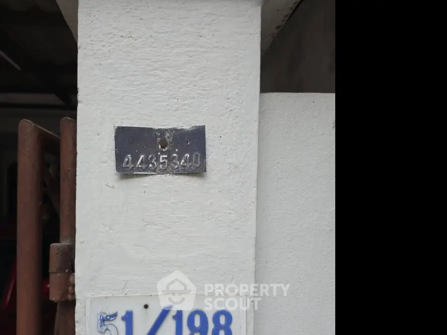 Exterior wall with house number plaque, showcasing unique property identification.