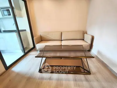 Modern living room with sleek glass coffee table and cozy beige sofa