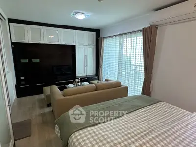 Cozy studio apartment with modern living area and large windows for natural light.