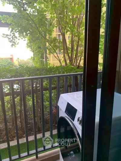 Charming balcony with lush greenery and modern washing machine, perfect for urban living.