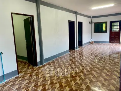 Spacious tiled room with multiple doorways and natural light