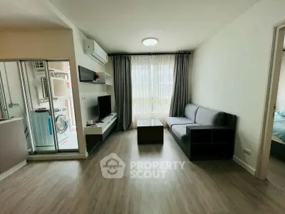 Modern living room with sleek furniture and natural light, featuring a compact open layout and stylish decor.