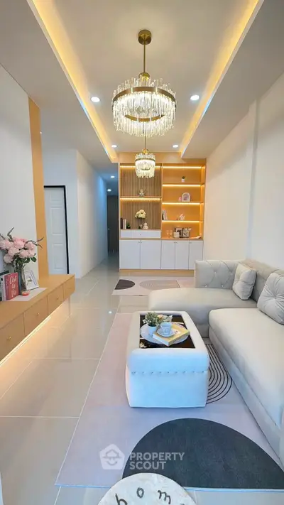Luxurious living room with elegant chandelier and plush sofa in modern apartment