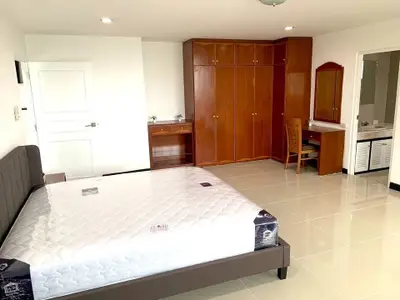 Spacious bedroom with modern furnishings and ample storage in a stylish apartment.