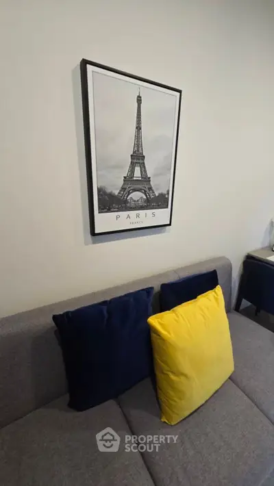 Stylish living room with modern sofa and Eiffel Tower artwork, perfect for urban living.