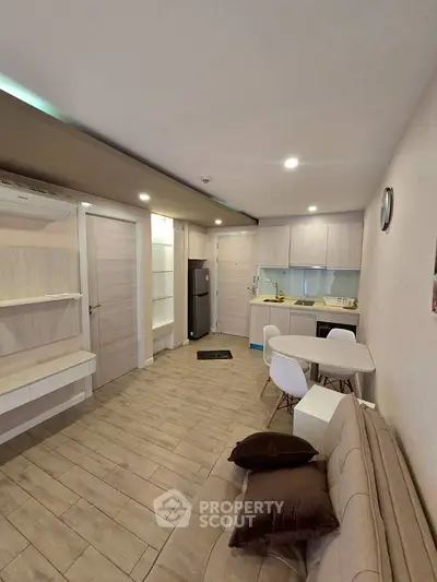 Modern open-plan living room and kitchen with sleek design and neutral tones.