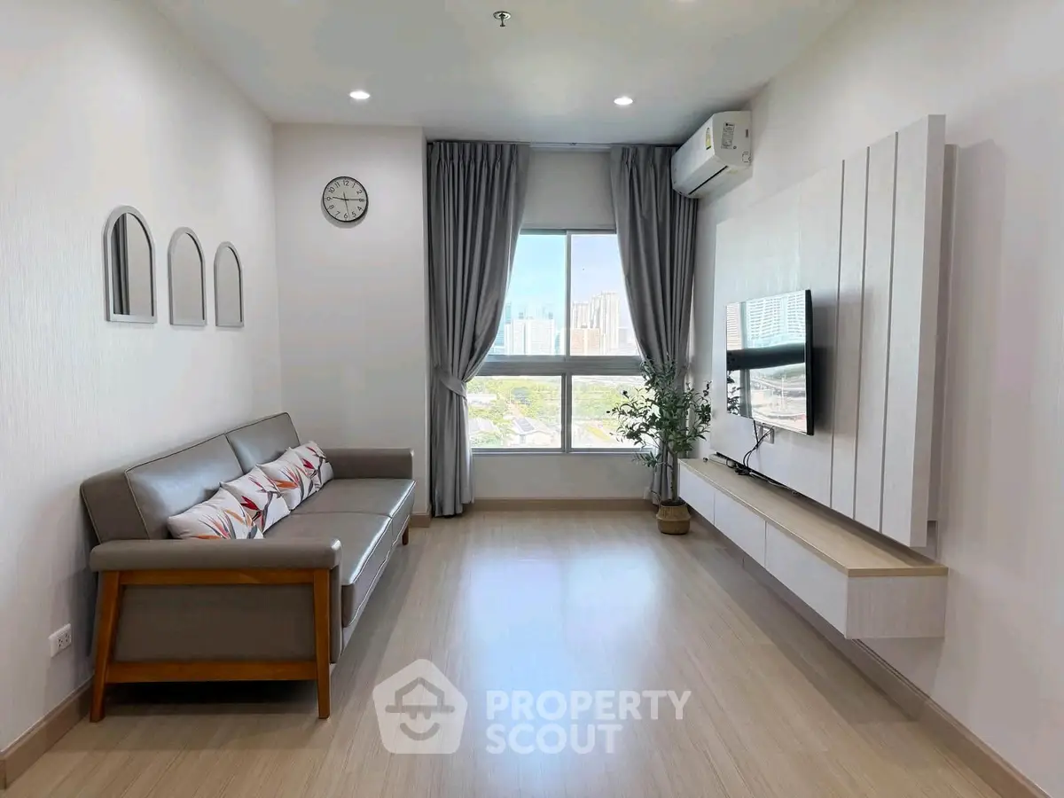 Modern living room with sleek design, large window, and wall-mounted TV in a stylish apartment.