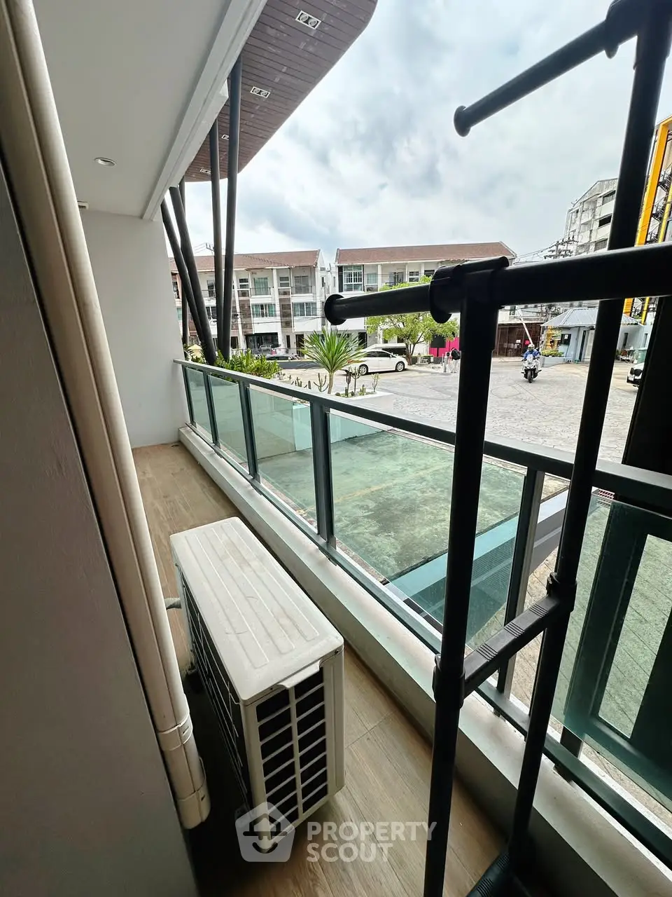 Modern balcony with glass railing and outdoor air conditioning unit