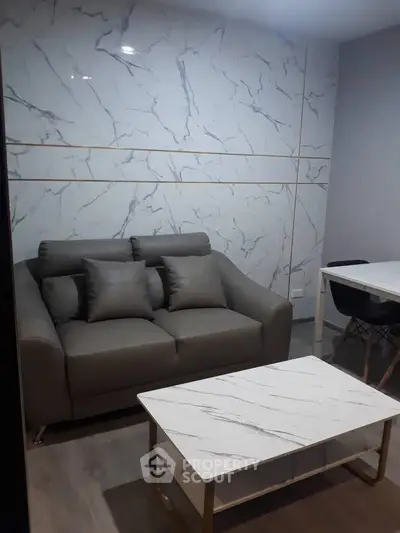 Modern living room with stylish marble wall and cozy gray sofa