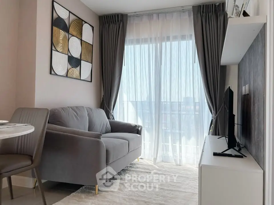 Modern living room with stylish decor and large window offering natural light.
