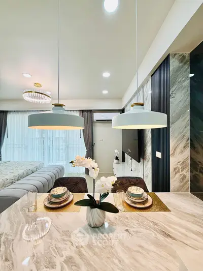 Luxurious modern living room with elegant dining setup and stylish lighting.