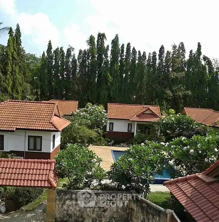 Charming villa complex with lush greenery and inviting pool area.