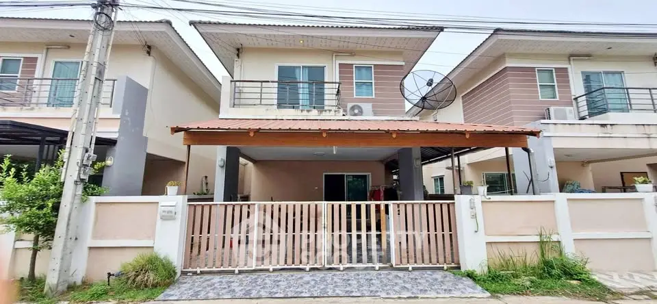 Modern two-story house with gated entrance and satellite dish, ideal for family living.