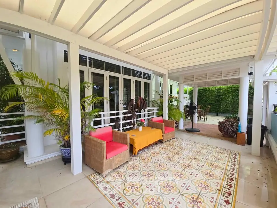 Charming outdoor patio with stylish furniture and lush greenery, perfect for relaxation and entertaining.