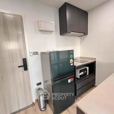 Modern kitchen with sleek appliances and minimalist design in a compact space.