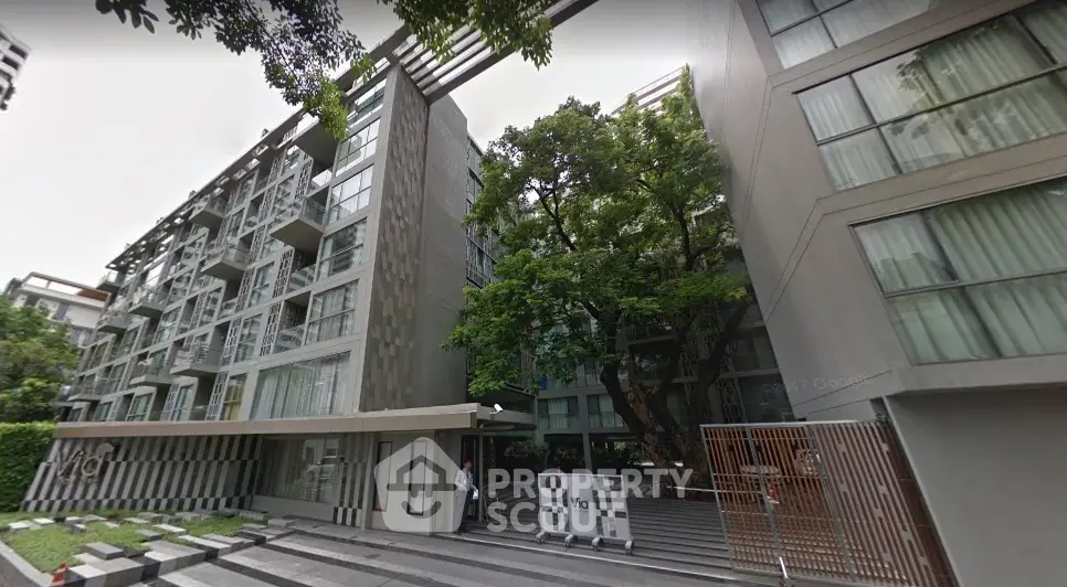 Modern apartment building with lush greenery and sleek architectural design.