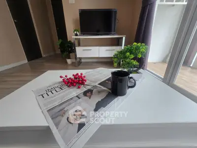 Modern living room with TV, stylish decor, and balcony access, perfect for relaxation.
