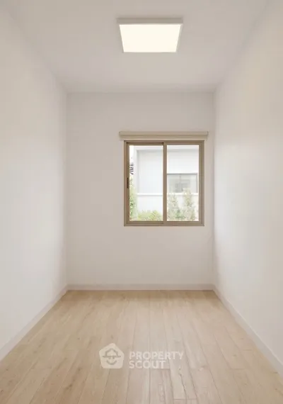 Minimalist small room with wooden flooring and window view