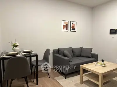 Modern living room with cozy gray sofa, stylish dining set, and minimalist decor.