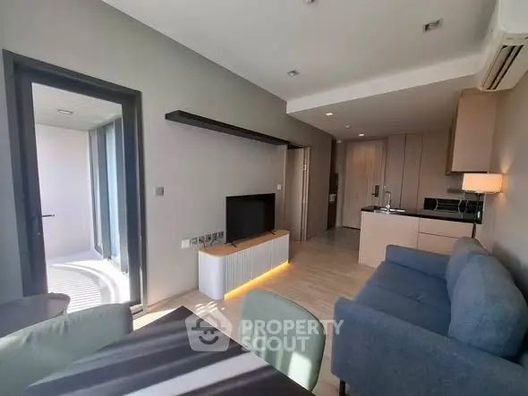 Modern living room with open kitchen and balcony access in stylish apartment