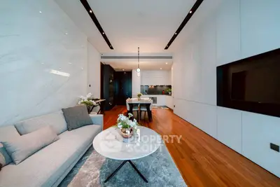 Modern living room with sleek design, featuring a cozy sofa, elegant dining area, and stylish open kitchen.