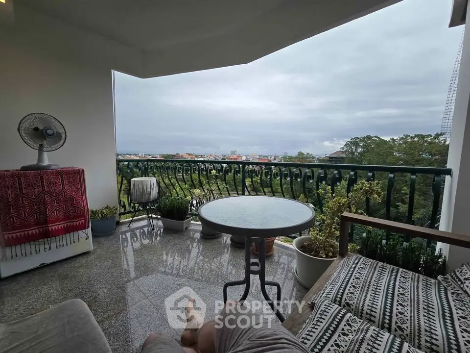 Spacious balcony with stunning city and greenery view, perfect for relaxation.
