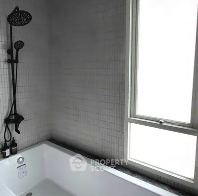 Modern bathroom with sleek shower and bathtub, featuring a large frosted window for natural light.