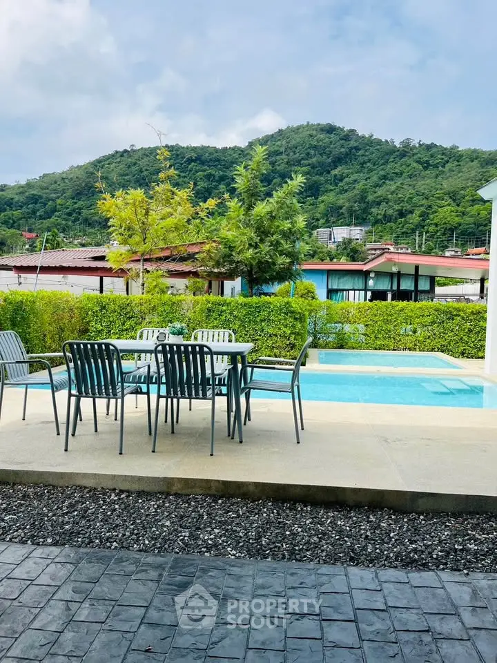 Charming outdoor patio with pool and scenic mountain view, perfect for relaxation and entertaining.