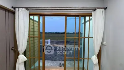 Charming interior view with sliding glass doors opening to a serene landscape.