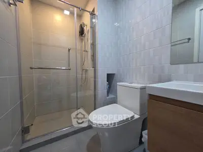 Modern bathroom with glass shower and sleek fixtures in a contemporary apartment.