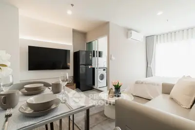 Modern studio apartment with open layout, featuring a cozy living area, kitchen, and bedroom with natural light.