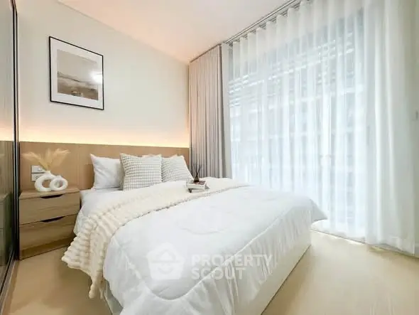 Bright and cozy bedroom with modern decor and large window for natural light.