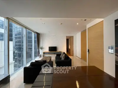 Spacious modern living room with large windows and sleek furniture in urban apartment.