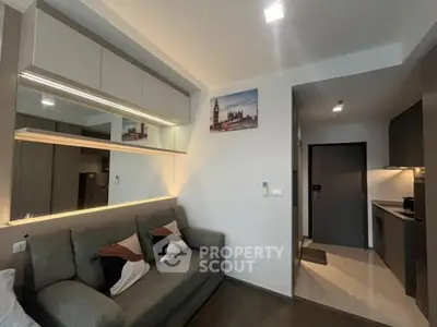 Modern living room with sleek kitchen in open layout apartment.
