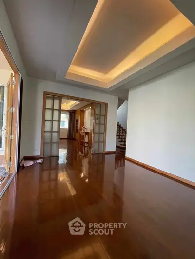 Spacious living room with wooden flooring and modern ceiling design