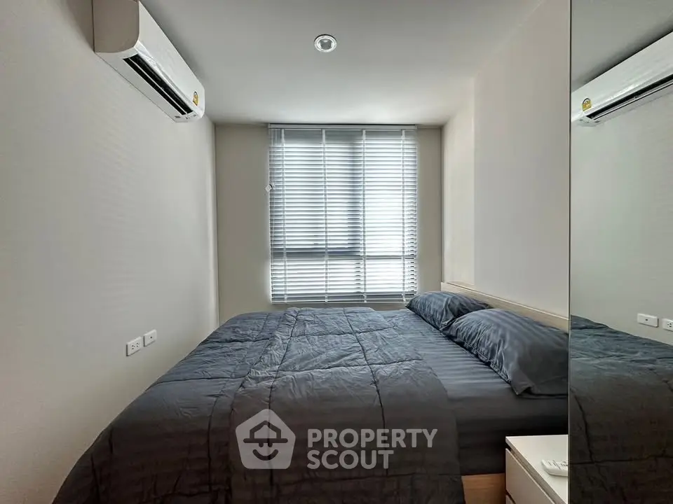 Modern bedroom with sleek design and ample natural light from large window.