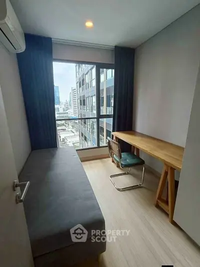 Modern study room with city view, featuring a sleek desk and comfortable chair, perfect for productivity.