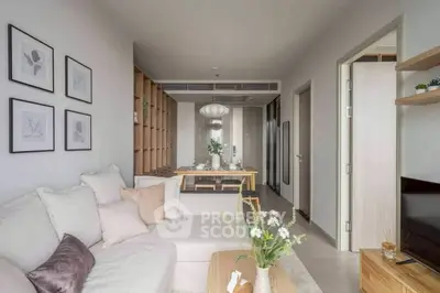 Modern living room with cozy sofa and elegant dining area in open layout apartment.