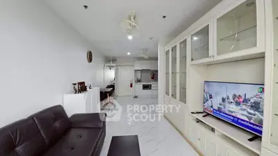 Spacious living room with modern furnishings and open kitchen layout, perfect for contemporary living.